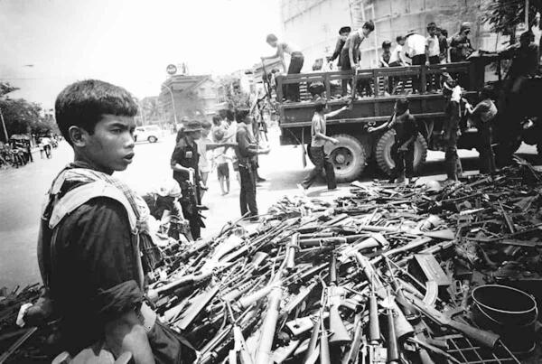 <span style="color: #000000 !important;font-size: 14pt">A child soldier witnesses the Fall of Phnom Penh in 1975, photo by Roland Neveu.</span>