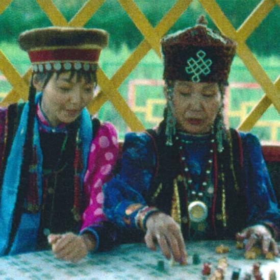 <span style="color: #000000 !important;font-size: 14pt">Irina plays a traditional board game with lamb bones. Both women are in traditional Buryat dress.</span>